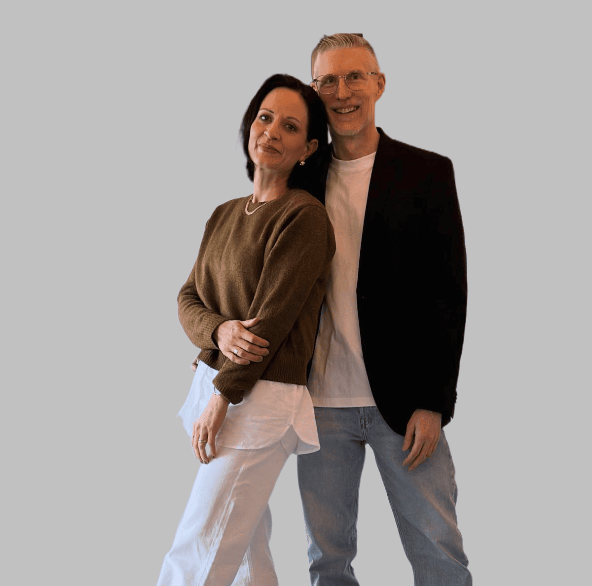 Pastorin Ester und Marco Kassebaum stehen lächelnd vor einer Wand“, entspannt nebeneinander in heller, freundlicher Umgebung.